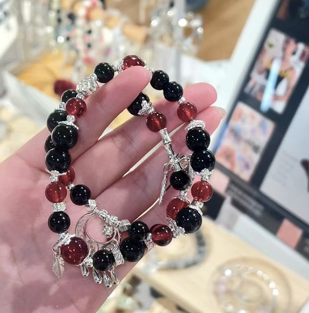 Dark red and black crystal bracelet held in hand