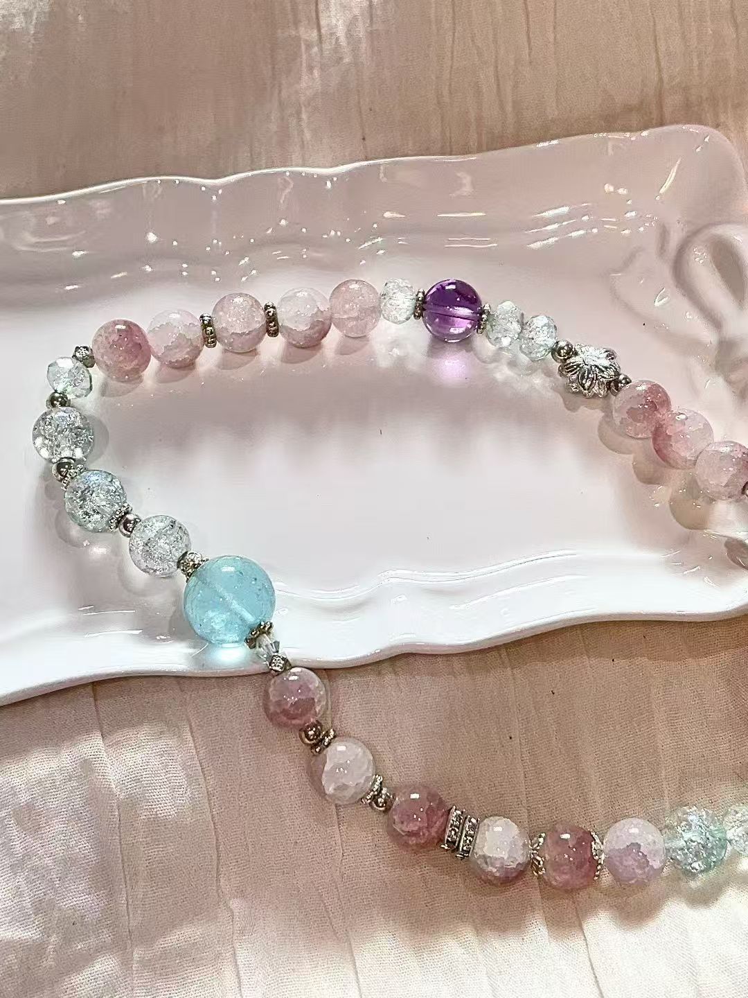 Pastel crystal bracelet arranged on a white tray