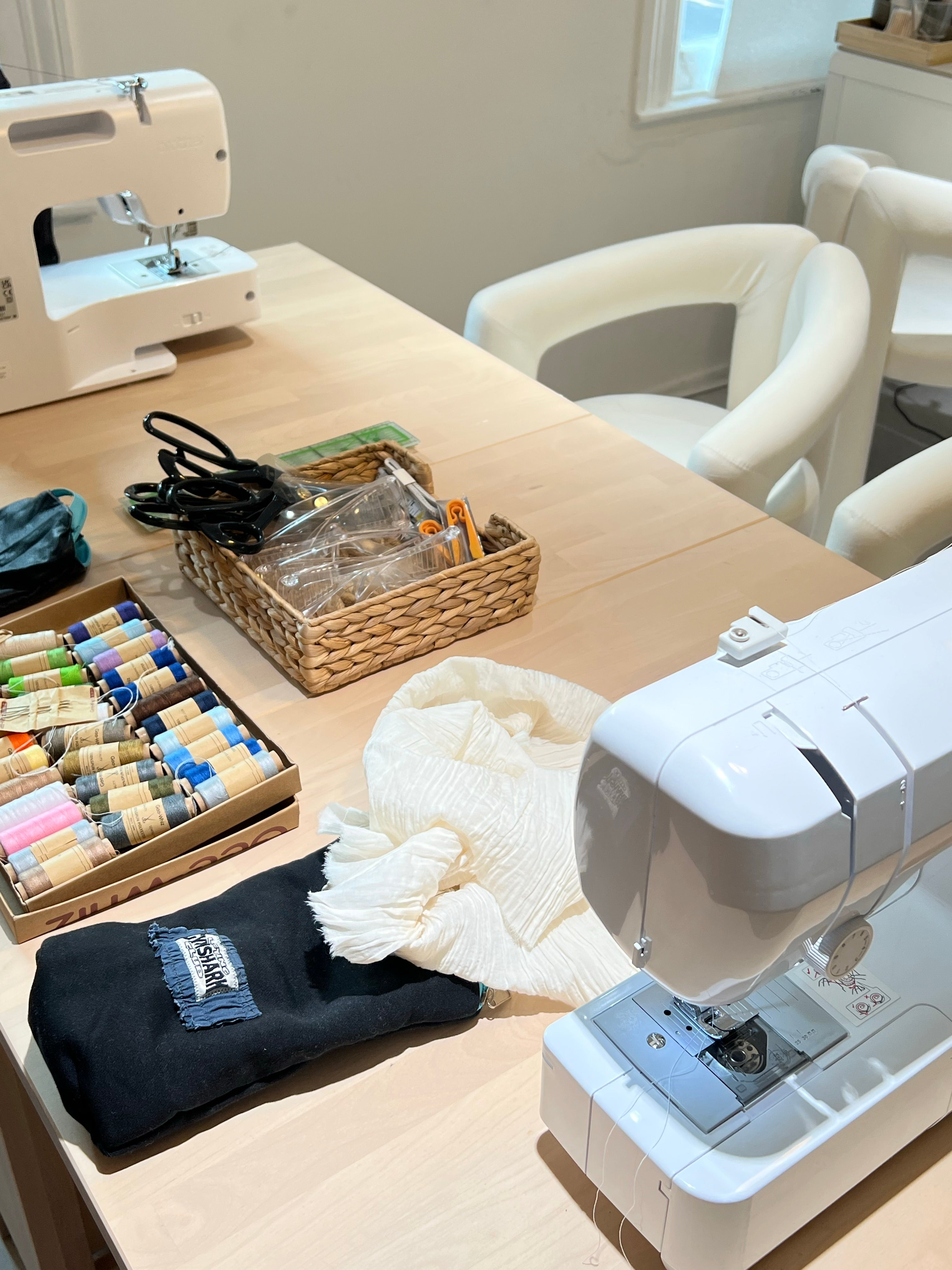 Sewing machines, thread, tools, and fabric in the Soho studio
