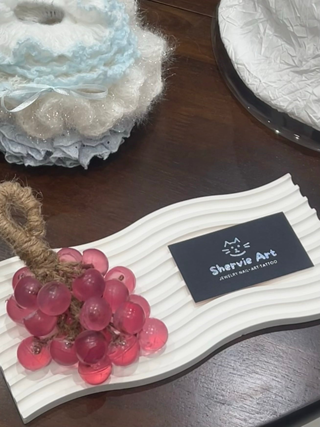 Pink grape-shaped handmade soap displayed on a tray with Shervie Art card