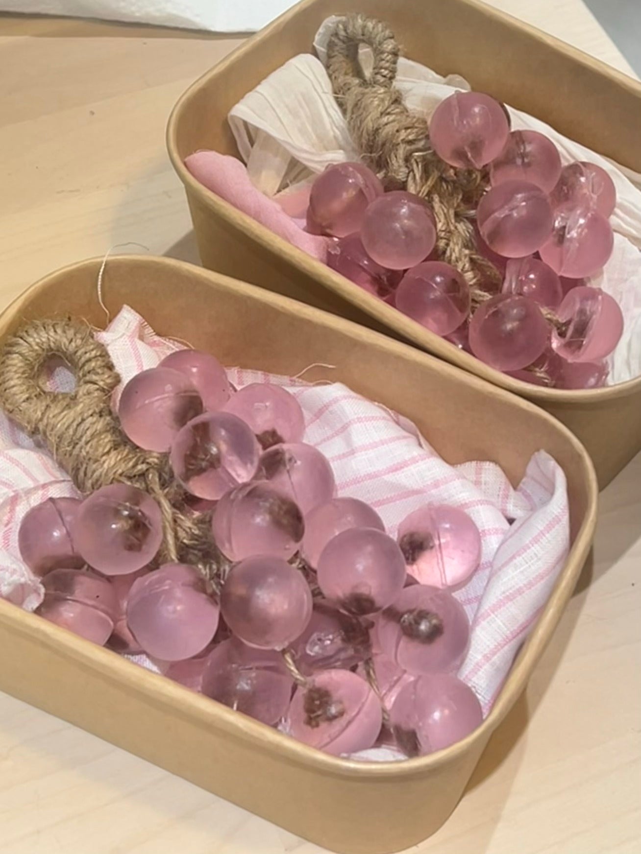 Pink grape-shaped handmade soaps arranged in gift boxes