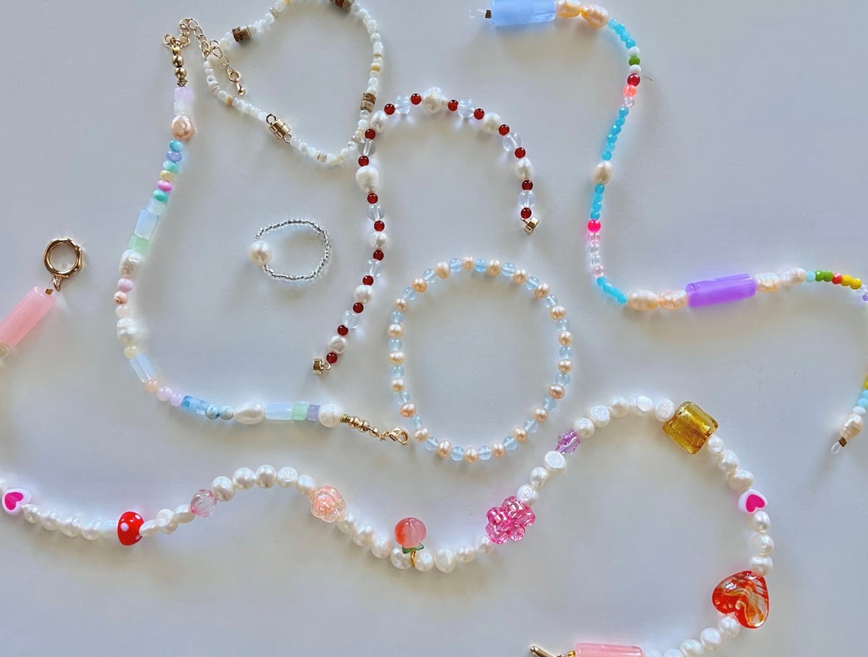 Handmade crystal and pearl bracelets arranged on a table