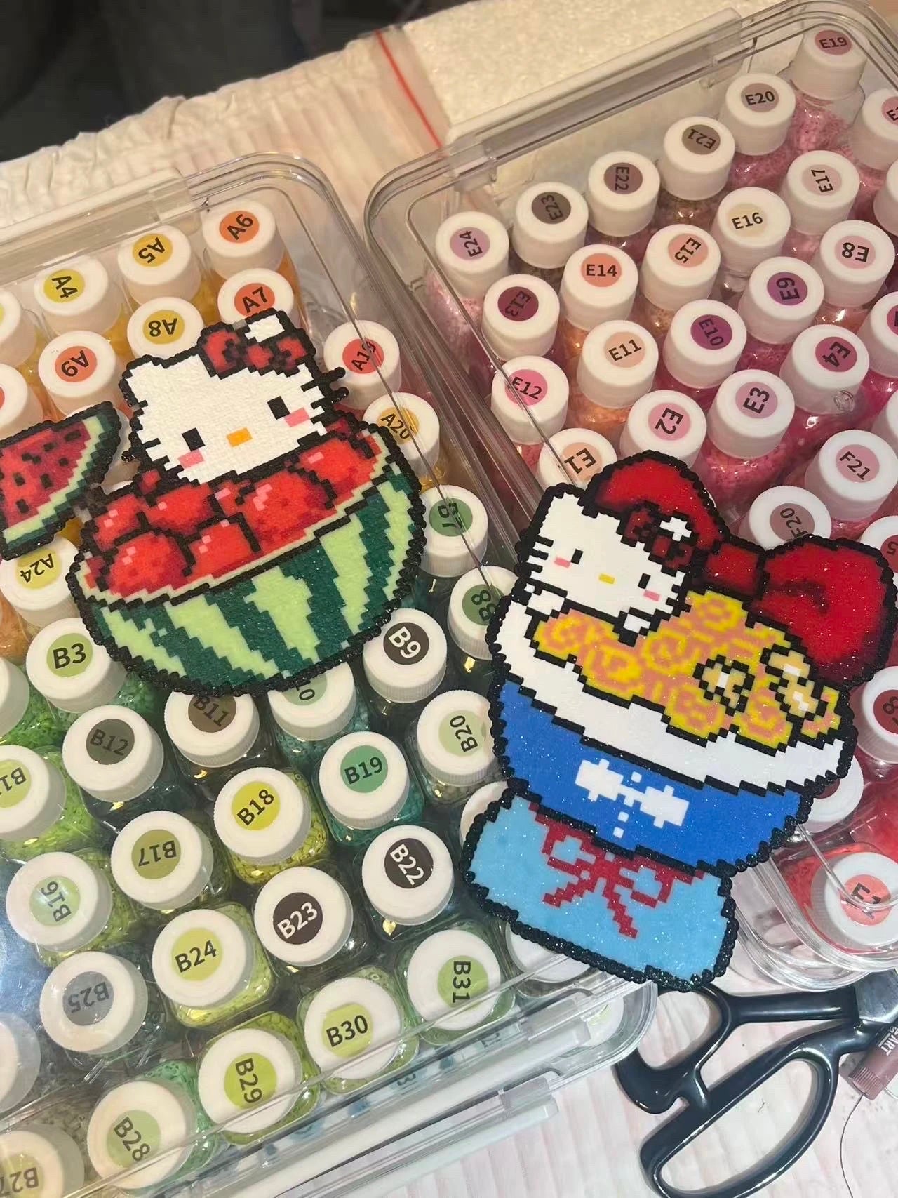 Hello Kitty perler bead artworks on top of colour bead boxes
