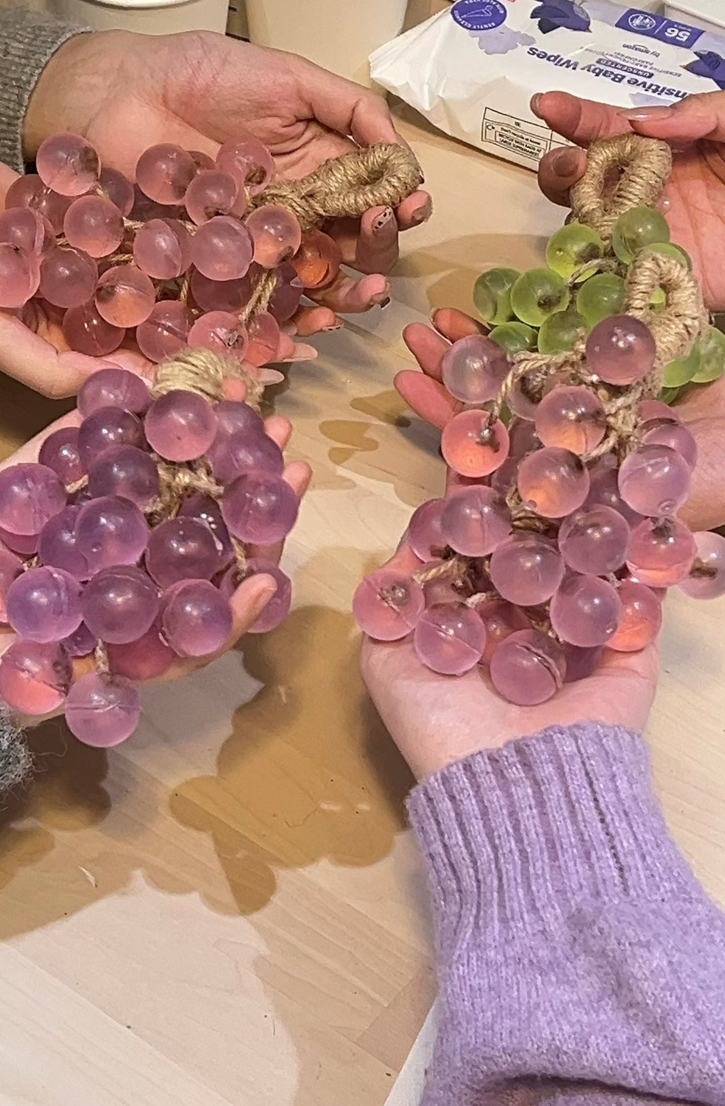 Participants holding handmade grape-shaped soap pieces