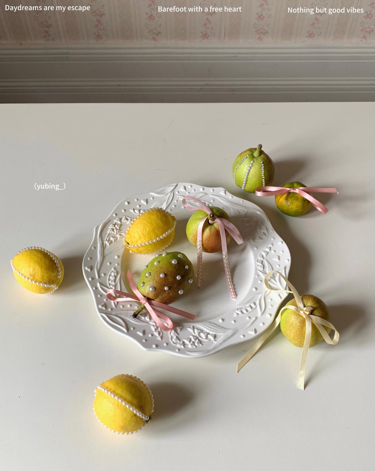Pearl and ribbon decorated fruit displayed on a white plate